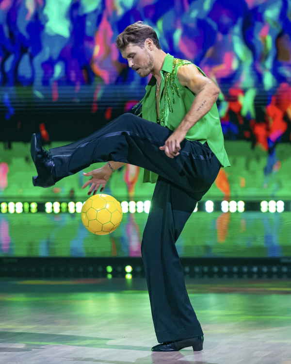 Football freestyler in Norway dressed in dress pants and green opened dress shirt while juggling football with feet | Altus Entertainment